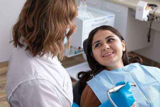 patient lying in a dental chair looking up at the technician smiling 