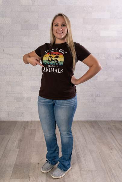 Halley McDaniel wearing a black t-shirt pointing to the word, animals on the front